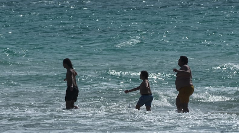 Beachgoers brave the cold ocean temperature while walking on a sandbar Thursday, Jan. 29, 2026, in Miami Beach, Fla. (AP Photo/Marta Lavandier)