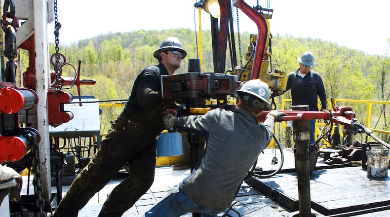 FILE - Workers move a section of well casing into place at a Chesapeake Energy natural gas well site near Burlington, Pa., in Bradford County, on April 23, 2010. (AP Photo/Ralph Wilson, File)
