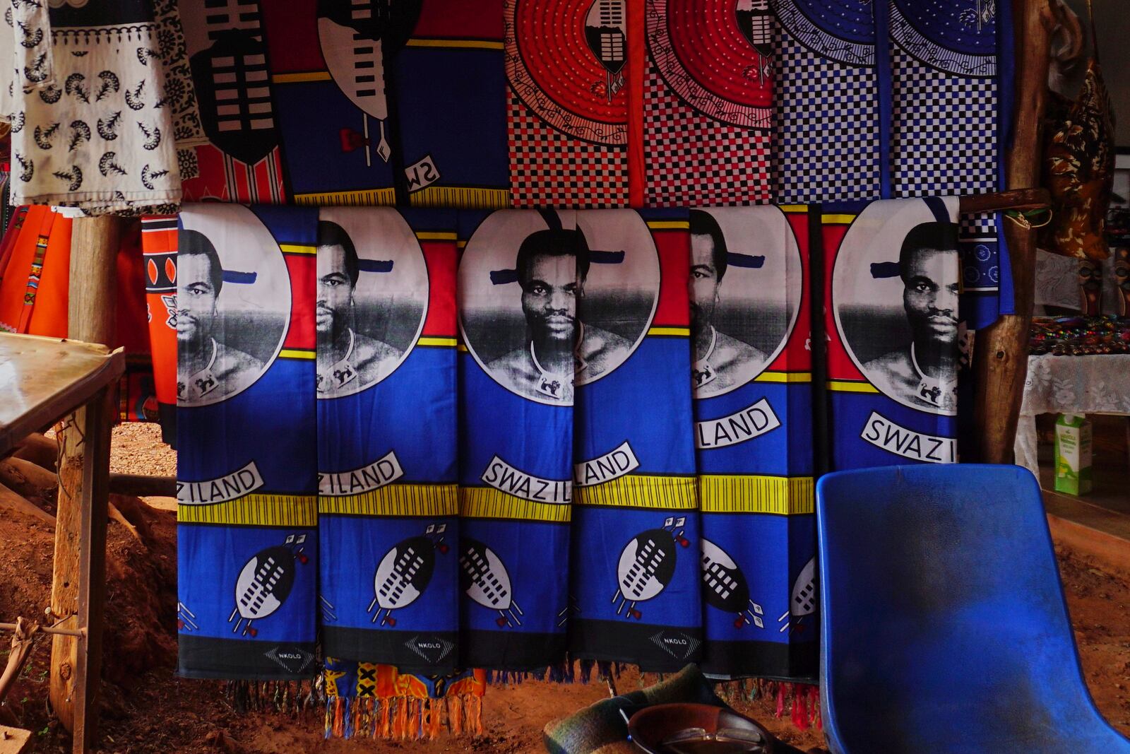 Cloths with King Mswati III's image sit for sale at a market in Lobamba, Eswatini, Friday, Aug. 17, 2018. (AP Photo/Jon Orbach)
