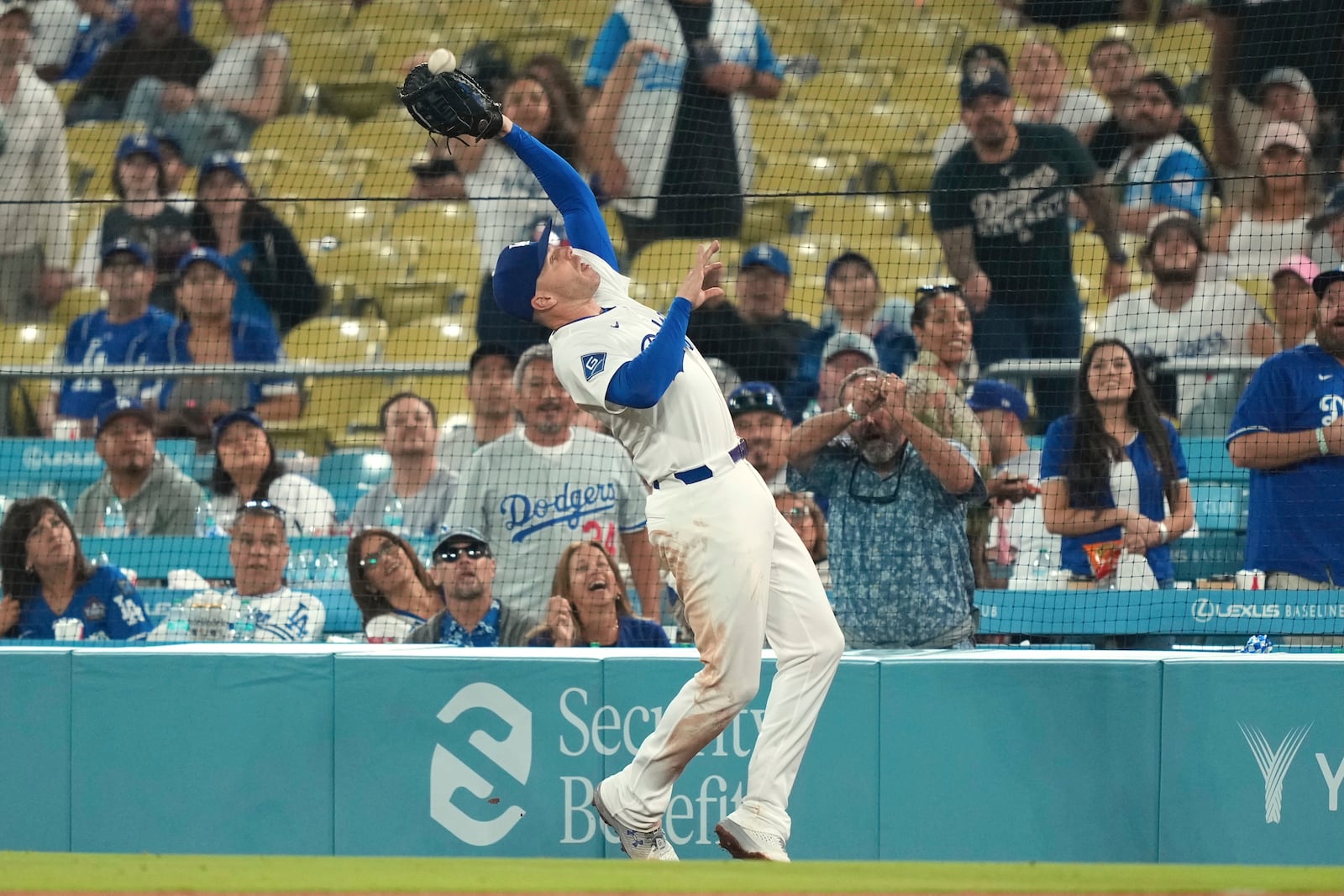 Los Angeles Dodgers first baseman Freddie Freeman makes a catch on a foul ball hit by Cincinnati Reds' Miguel Andujar during the ninth inning of a baseball game Tuesday, Aug. 26, 2025, in Los Angeles. (AP Photo/Mark J. Terrill)