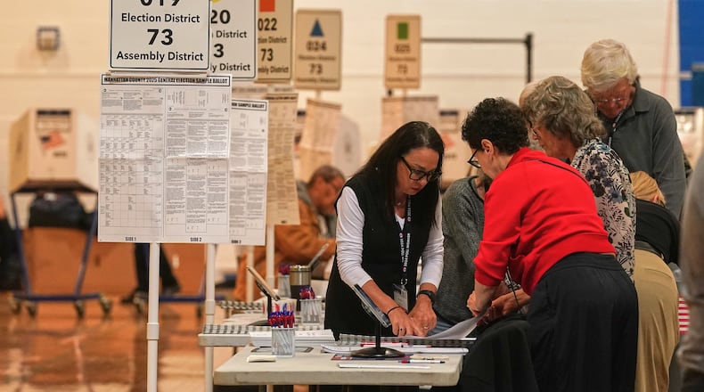 Workers prepare for voters at a poll site, in New York, Tuesday, Nov. 4, 2025. (AP Photo/Richard Drew)