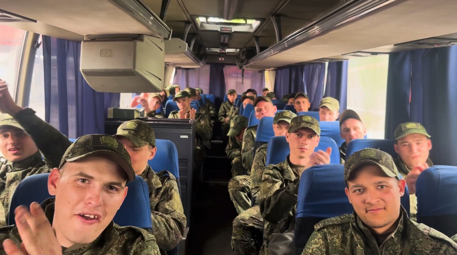 In this photo taken from video distributed by Russian Defense Ministry Press Service on Tuesday, May 6, 2025, a group of Russian soldiers applaud as they sit in a bus after being released in a prisoners swap between Russia and Ukraine, at the Ukraine-Belarusian boarder. (Russian Defense Ministry Press Service via AP)