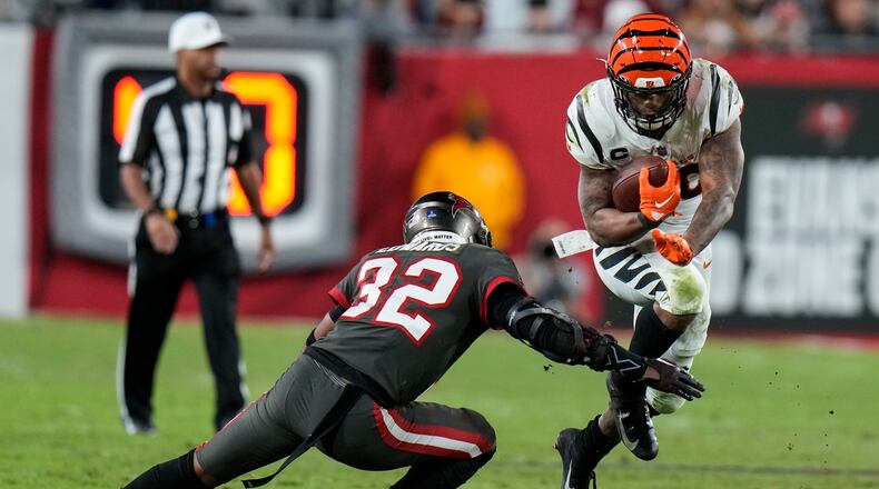 Cincinnati Bengals running back Joe Mixon (28) leaps near Tampa Bay Buccaneers safety Mike Edwards (32) during the second half of an NFL football game, Sunday, Dec. 18, 2022, in Tampa, Fla. (AP Photo/Chris O'Meara)
