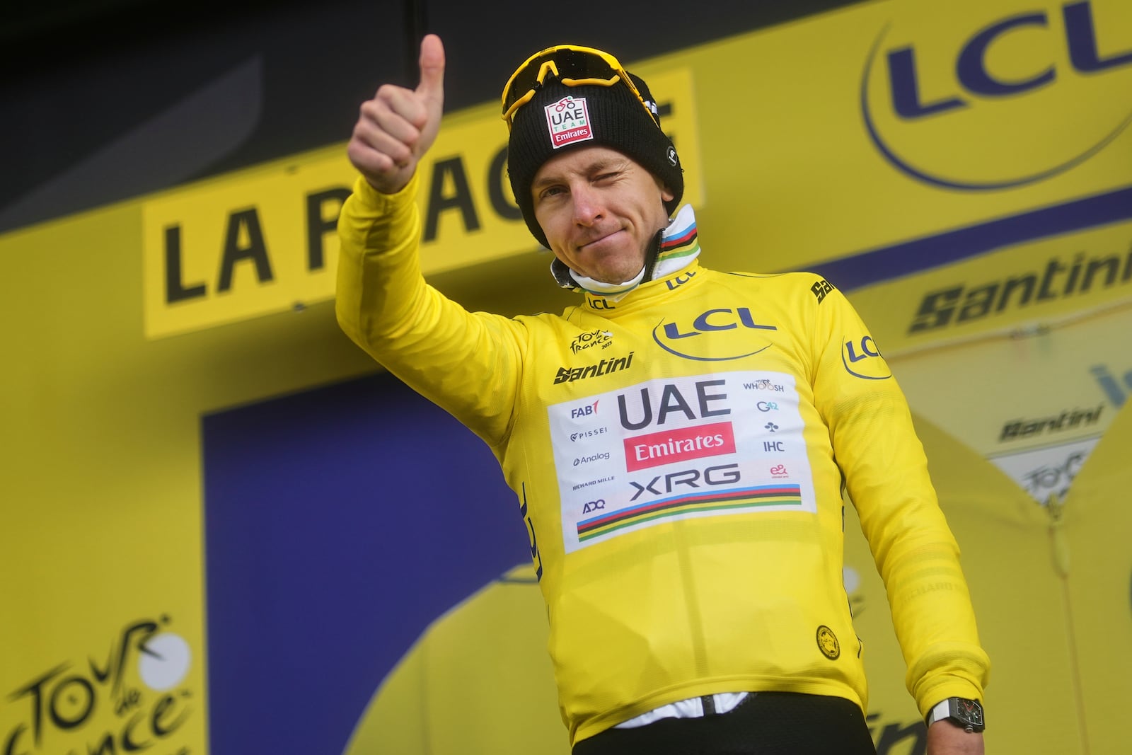 Slovenia's Tadej Pogacar, wearing the overall leader's yellow jersey, celebrates on the podium after the nineteenth stage of the Tour de France cycling race over 93.1 kilometers (57.85 miles) with start in Albertville and finish in La Plagne, France, Friday, July 25, 2025. (AP Photo/Thibault Camus)