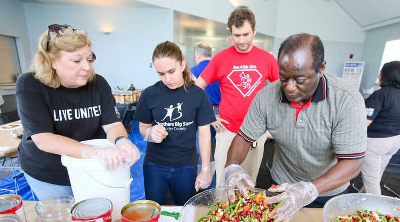 Margaret Baker, president and CEO of the Butler County United Way; Nancie Ehlert and Matt Flynn of Big Brothers Big Sisters of Butler County; and Lonnie Tucker, chairman of the Butler County United Way Impact Council prepare soup as part of a 2016 event benefiting Serve City in Hamilton. GREG LYNCH / STAFF