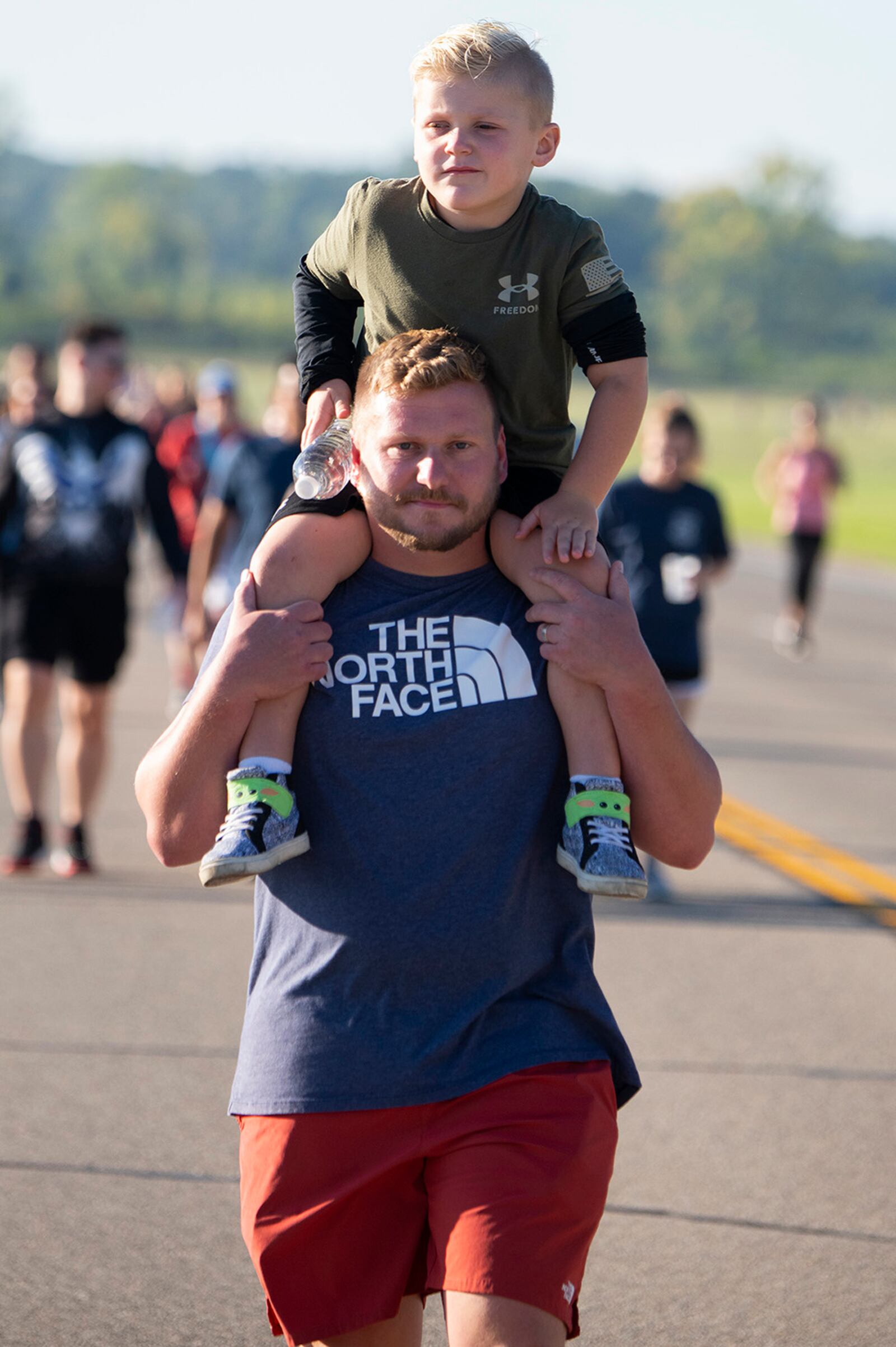 Jon Taylor, Air Force Materiel Command headquarters, and his son, Maverick, 5, take part in the 2-kilometer walk portion of Run for the Fallen on Sept. 9 at Wright-Patterson Air Force Base’s Area B. Taylor said it was important for his son to know about the 9/11 terrorist attacks. U.S. AIR FORCE PHOTO/R.J. ORIEZ