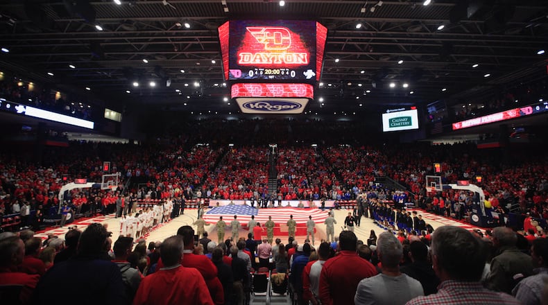 PHOTOS FROM THE BOOK: The Epicenter of College Basketball: A History of UD Arena — Fans stand for the national anthem before a game between Dayton and Indiana State in 2019 at UD Arena. This was the first men’s basketball game since the end of a three-year renovation project that transformed the 50-year old arena. Dayton Daily News photo by David Jablonski