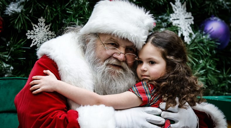 Lilly Harris, from Peebles Ohio, gives Santa a hug at the Dayton Mall Wednesday December 21, 2022. Harris is visiting relatives in Dayton. JIM NOELKER/STAFF