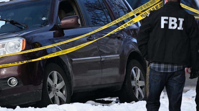 A bullet hole is seen in the windshield as law enforcement officers work the scene of a shooting involving federal law enforcement agents, Wednesday, Jan. 7, 2026, in Minneapolis. (AP Photo/Tom Baker)