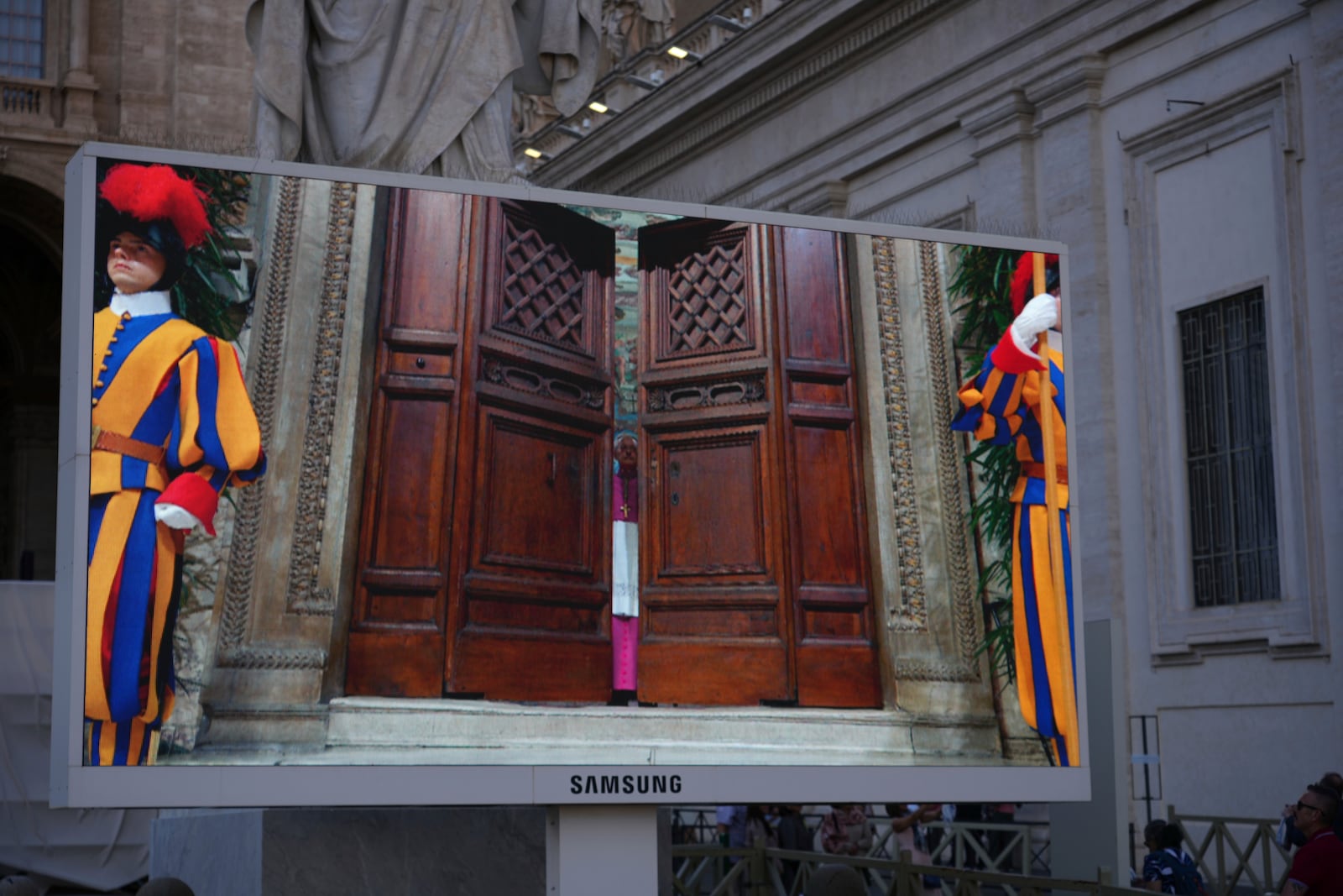 A giant screen shows Swiss Guards standing as the door of the Sistine Chapel is being closed, during the conclave to elect a new pope, at the Vatican, Wednesday, May 7, 2025. (AP Photo/Andrew Medichini)