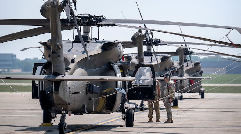 Crew members stand near U.S. Army UH-60M Black Hawk helicopters that will participate in an upcoming military parade commemorating the Army's 250th anniversary and coinciding with President Donald Trump's 79th birthday, at Joint Base Andrews, Md., Thursday, June 12, 2025. (AP Photo/Mark Schiefelbein)