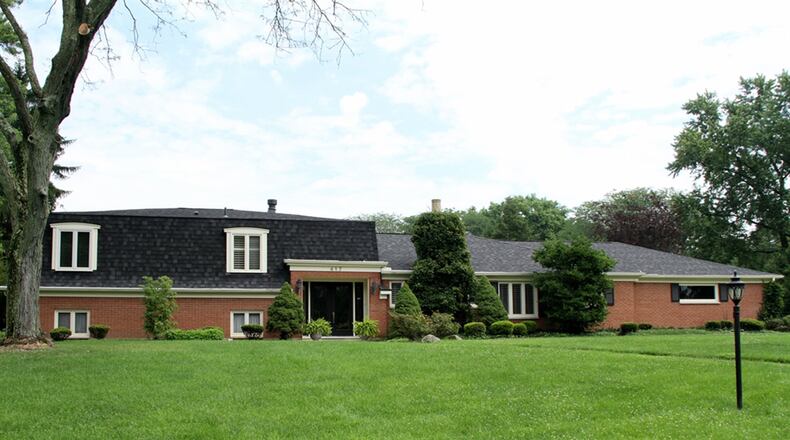 The brick tri-level at 417 Chowning Circle in Kettering sits on a 1.31-acre, corner lot with a 3-car garage and a courtyard patio with a pergola and retractable awning. CONTRIBUTED PHOTOS BY KATHY TYLER