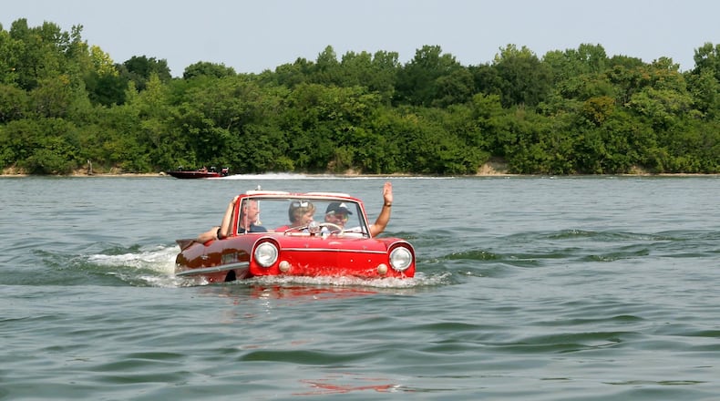 Mike Bayman waves to another boater as he takes a cruise in Eastwood Lake in his Amphicar during British Car Day 2007. Amphicars are powered by British-built Triumph engines. You can see a contingent of Amphicars as they take part in the Celina Lake Festival’s Grand Parade July 29. Skip Peterson photo