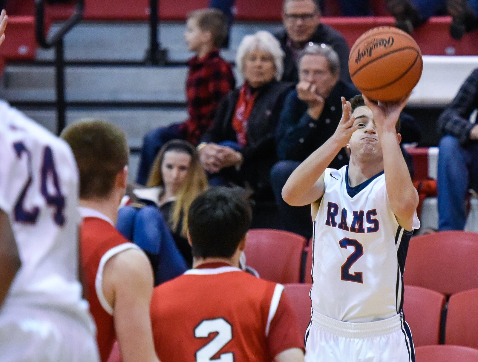 Miami Valley’s Chase Harlan (2, white) launches a shot over Madison’s Ryan Friend (2, red) on Thursday night during the Brian Cook Classic at Madison. NICK GRAHAM/STAFF