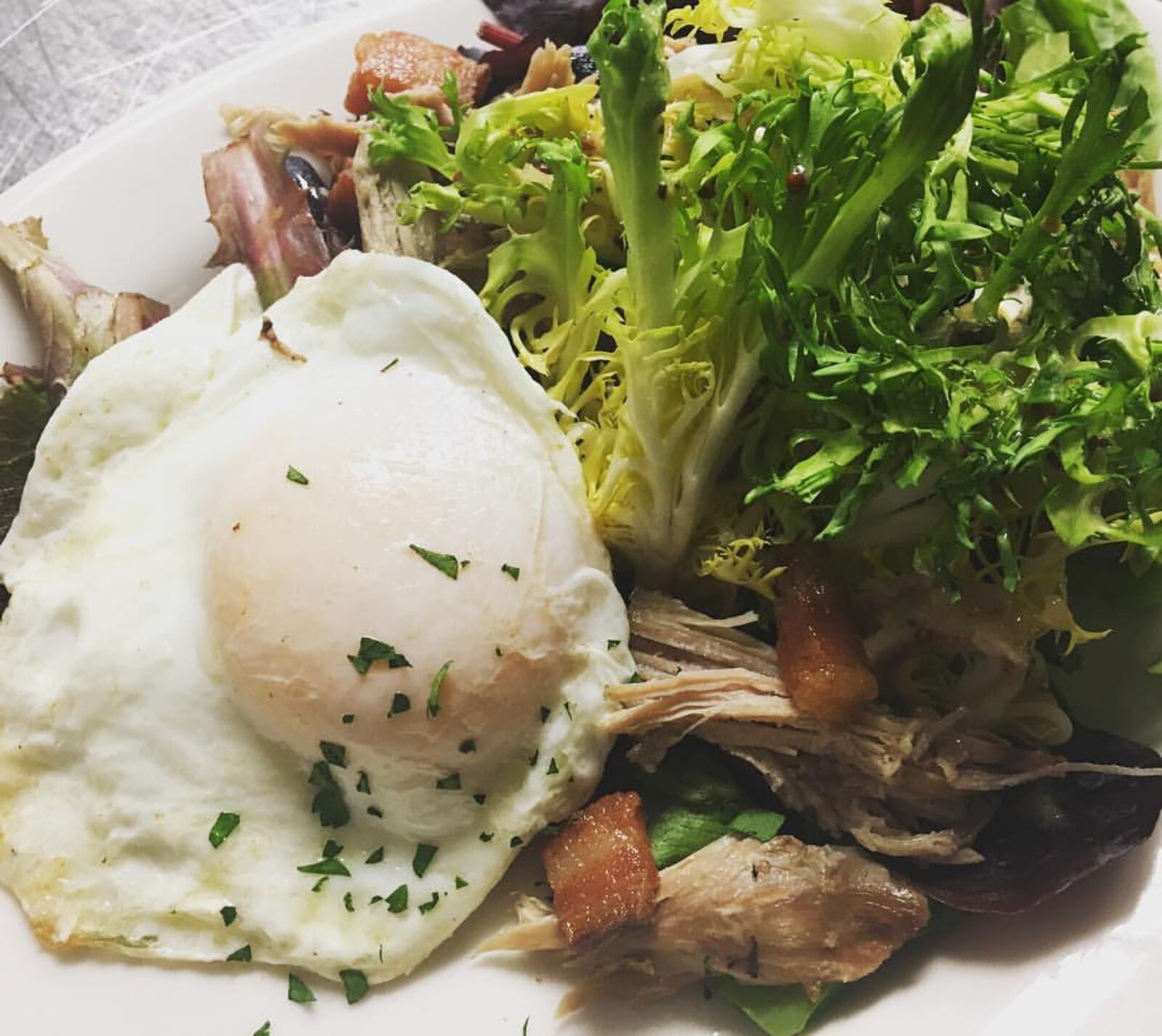 "The Leg" is just one of the Valentine's Day dishes featured at Corner Kitchen from Feb. 14-18, 2017. This dish of duck confit salad includes frisee, quail egg, warm mustard vinaigrette, and bacon. CONTRIBUTED