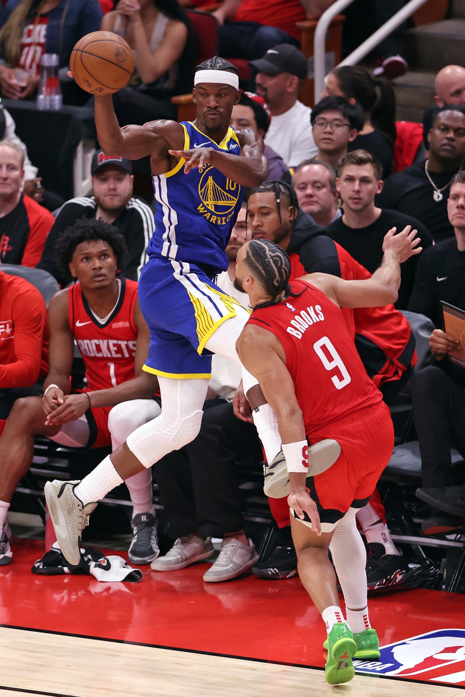 Golden State Warriors' Jimmy Butler III saves the ball from going out of bounds against Houston Rockets' Dillon Brooks (9) during the second half of Game 1 of an NBA basketball first-round playoff series in Houston, Sunday, April 20, 2025. (Scott Strazzante/San Francisco Chronicle via AP)