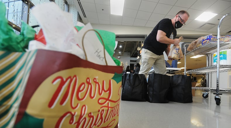 A Southbrook Christian Church volunteer places food items into bags, Sunday, Dec. 20, 2020. The food will be distributed to people in need. MARSHALL GORBY\STAFF