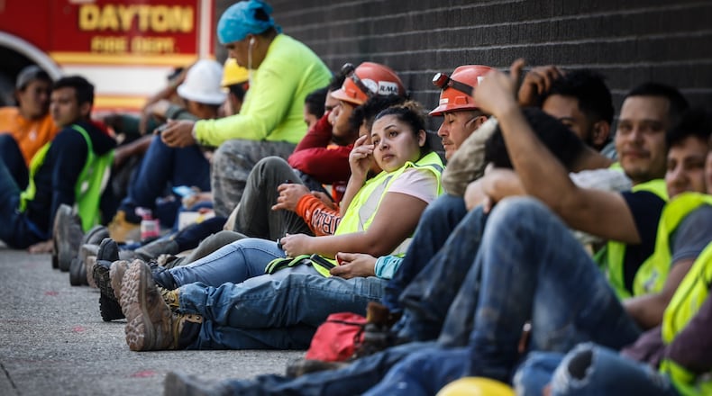 Construction workers who are rehabbing Mendelson in downtown Dayton rest in the shade after a tank on the roof caught fire and they evacuated the building. The fire did not damage the seven story building. JIM NOELKER/STAFF