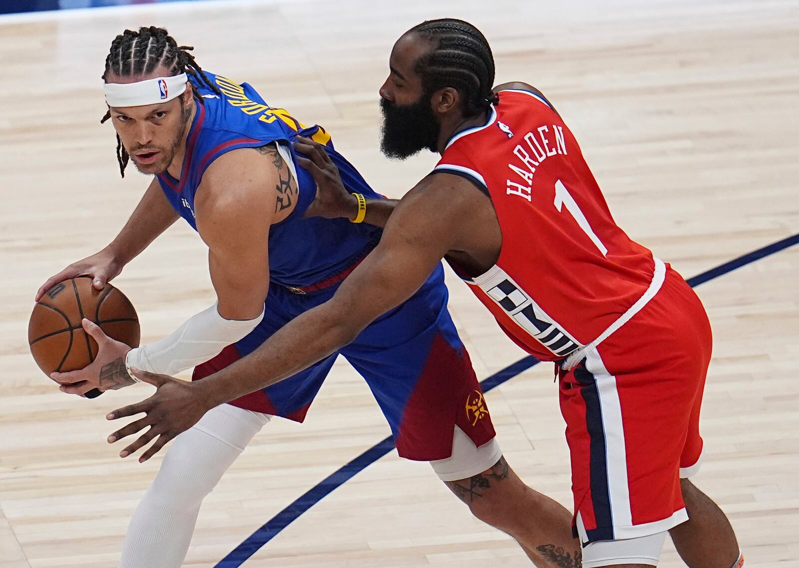 Denver Nuggets forward Aaron Gordon, left, looks to pass the ball as Los Angeles Clippers guard James Harden, right, defends in the first half of Game 1 of an NBA first-round playoff series Saturday, April 19, 2025, in Denver. (AP Photo/David Zalubowski)