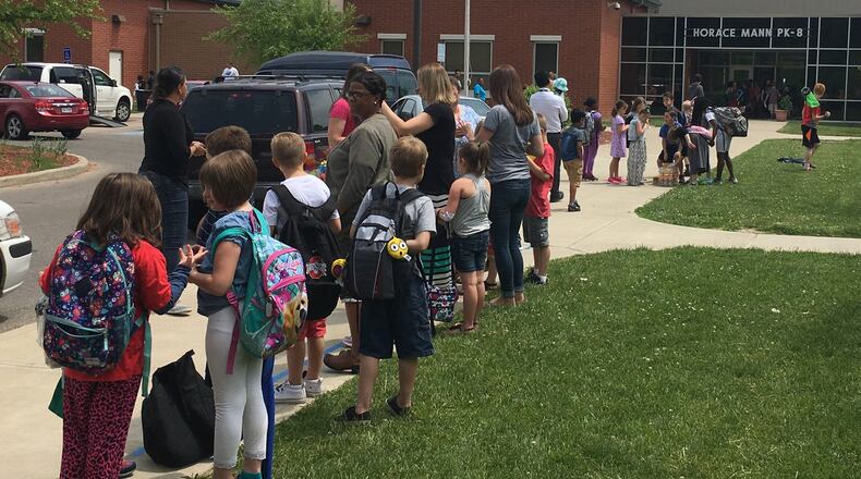 Students, teachers and parents gather outside Horace Mann Elementary School in Dayton at the end of a school day. Horace Mann had the second-highest attendance rate of Dayton Public Schools in the first semester. JEREMY P. KELLEY / STAFF