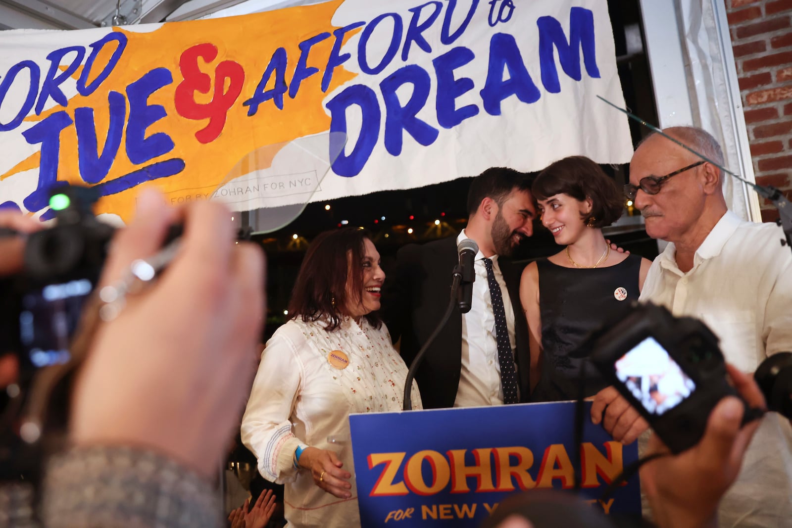 Democratic mayoral candidate Zohran Mamdani on stage with his family including his mother, Mira Nair, left, his wife, Rama Duwaji, and father, Mahmood Mamdani, right, at his primary election party, Wednesday, June 25, 2025, in New York. (AP Photo/Heather Khalifa)