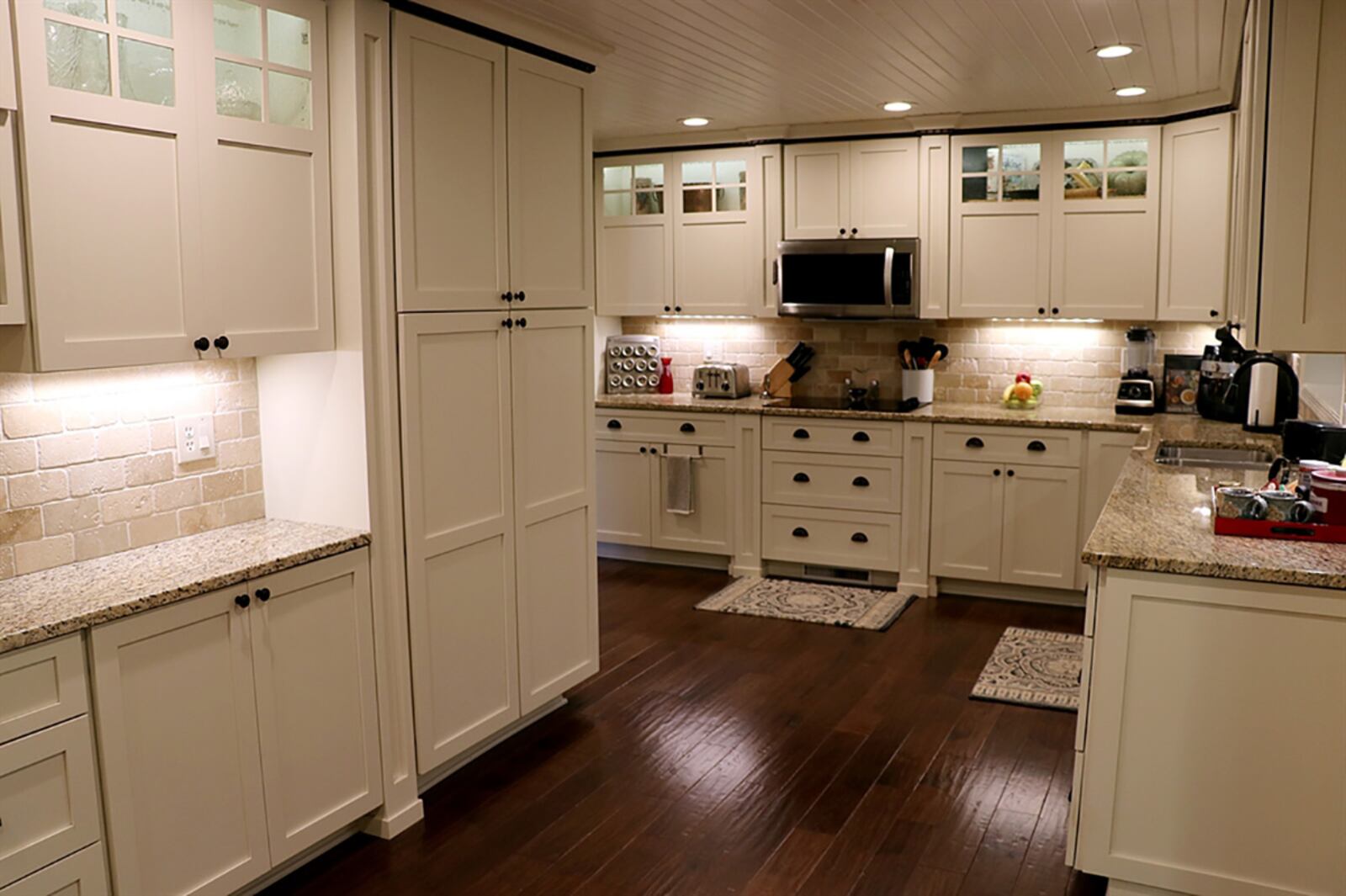 The kitchen is the centerpiece to the floor plan. Granite countertops complement the off-white cabinetry that includes a pantry. A double sink is below a pass-through window that looks into the family room. Along one wall of the breakfast room is a buffet counter with additional cabinetry and drawers. CONTRIBUTED PHOTO BY KATHY TYLER