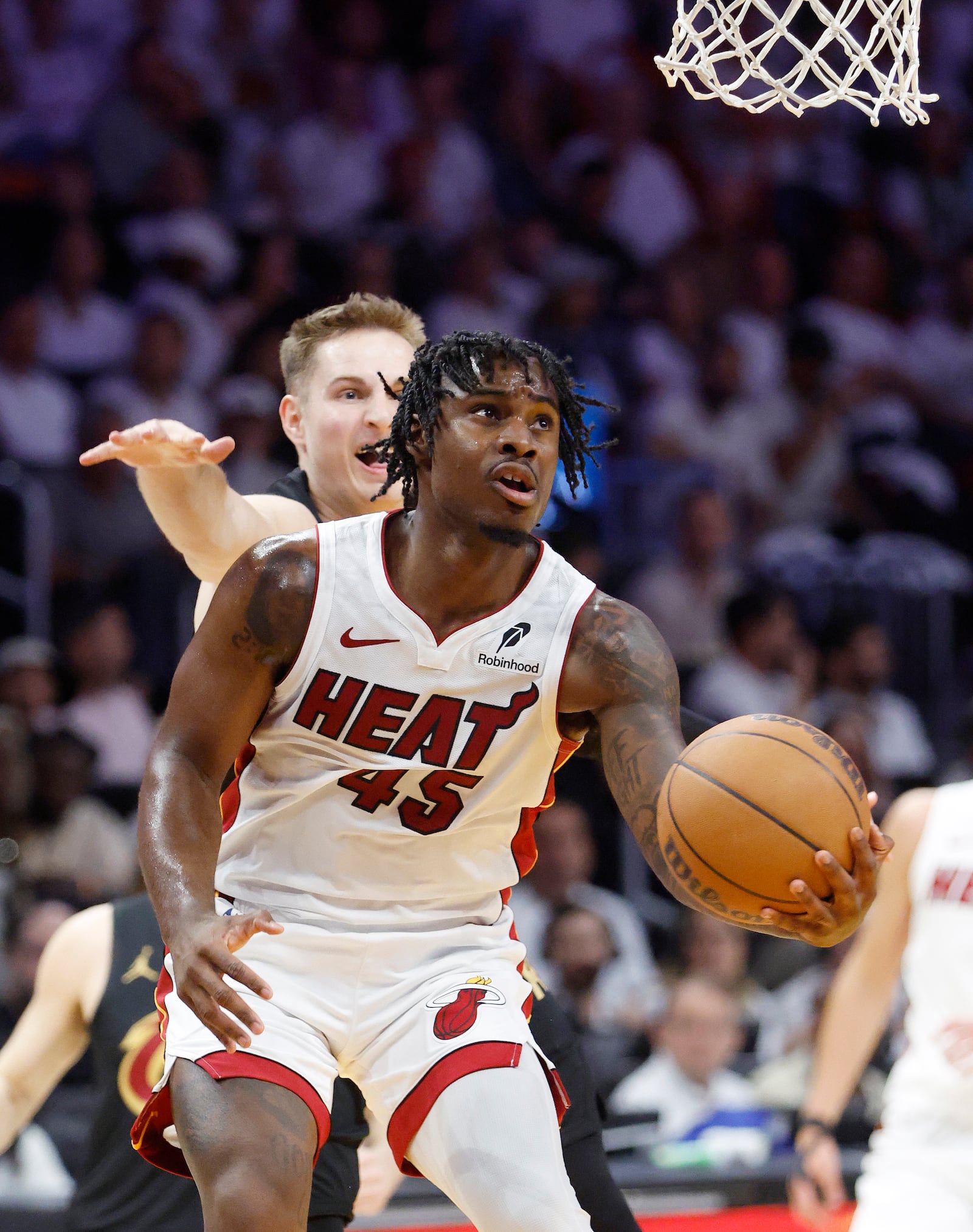 Miami Heat guard Davion Mitchell (45) looks to shoot in front of Cleveland Cavaliers guard Sam Merrill, back, during the first half in Game 4 of an NBA basketball first-round playoff series, Monday, April 28, 2025, in Miami. (AP Photo/Rhona Wise)