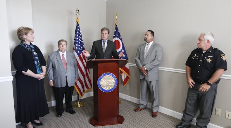 U.S. Rep. Mike Turner (center), R-Dayton, and Montgomery County Sheriff Phil Plummer (right) have sent a letter asking leaders of the Dayton Area Chamber of Commerce and Dayton Development Coalition to help select a Dayton regional drug czar to coordinate a response to the opioid crisis. They announced the effort Sept. 25. The others from left are Fairborn Municipal Court Judge Beth Cappelli, Greene County Commissioner Bob Glaser and Dr. Jean Wright, who is involved in combating the crisis in Philadelphia. CHRIS STEWART / STAFF