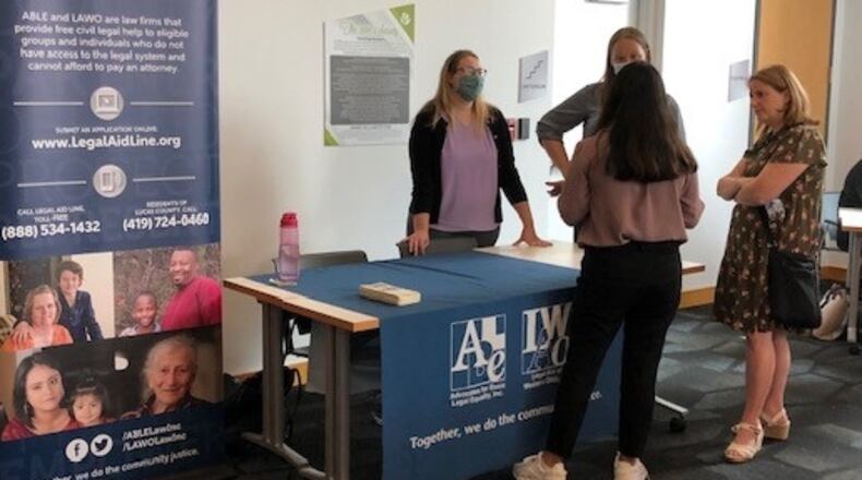 ABLE's table at a recent Welcome Dayton event with staff speaking with one of the Afghan refugee attendees. CONTRIBUTED