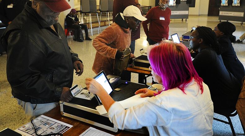 Willie Finklea, left, registers to vote at the Dayton Masonic Center Tuesday, May 2, 2023. MARSHALL GORBY\STAFF