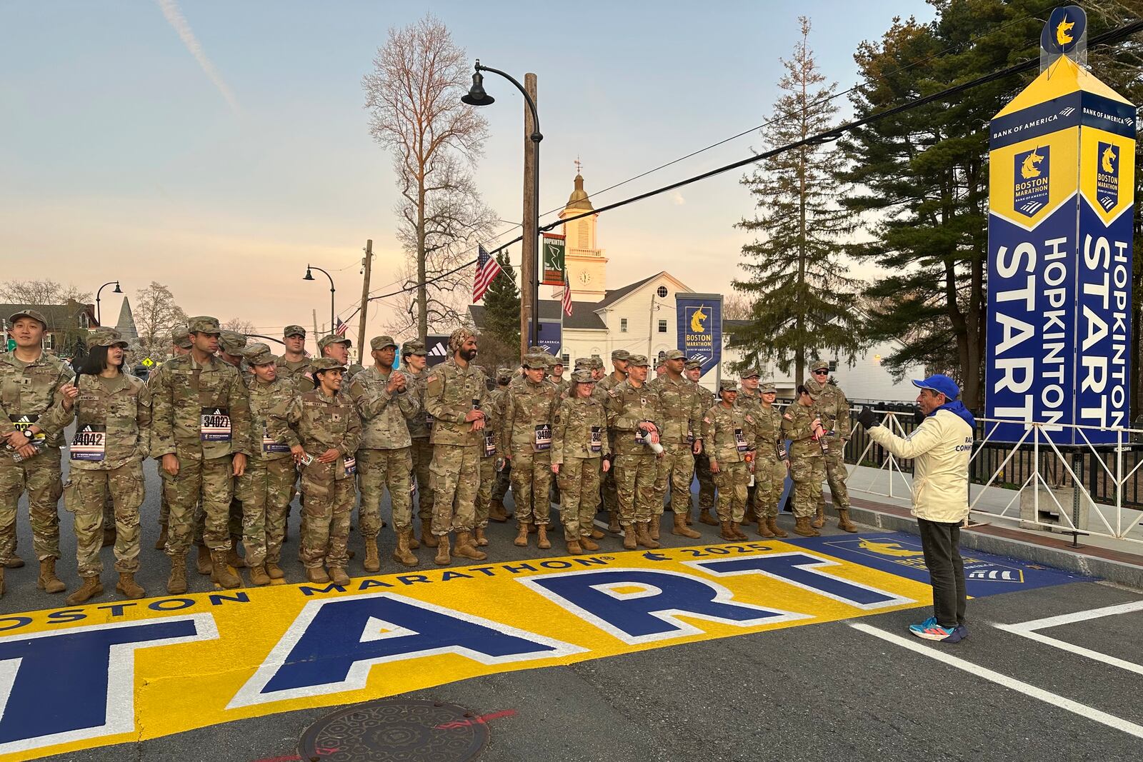 Boston Marathon Race Director Dave McGillivray, right, sends a group of Massachusetts National Guard members across the start line, launching the 129th edition of the race, in Hopkinton, Mass, early Monday, April 21, 2025. (AP Photo/Jennifer McDermott)