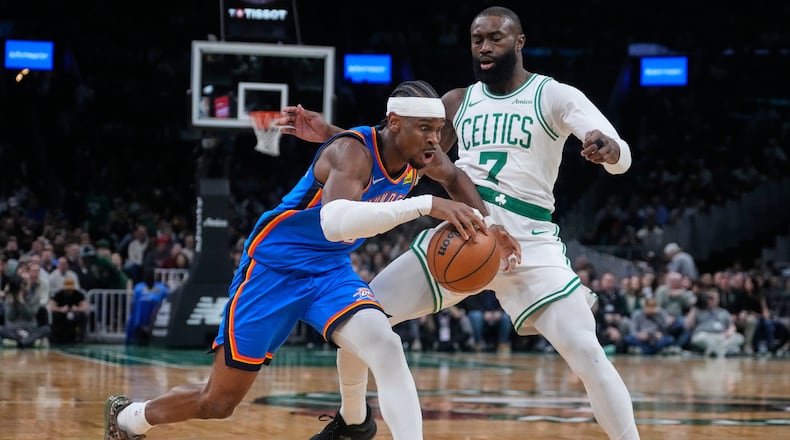 Oklahoma City Thunder guard Shai Gilgeous-Alexander, left, drives to the basket against Boston Celtics guard Jaylen Brown (7) during the first half of an NBA basketball game, Wednesday, March 25, 2026, in Boston. (AP Photo/Charles Krupa)