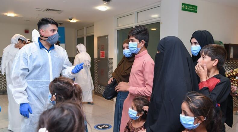 Lt. Col. Asim Khan, Language Enabled Airman Program scholar and director of staff, U.S. Air Forces Central Air Warfare Center, Al Dhafra Air Base, United Arab Emirates, helps transition Afghan evacuees from Abu Dhabi International Airport to the Emirati Humanitarian City during the evacuation of American citizens, special immigrant visa applicants and other at-risk individuals from Afghanistan in August 2021. U.S. AIR FORCE PHOTO/MAJ. ARTEMIS WINKLEY