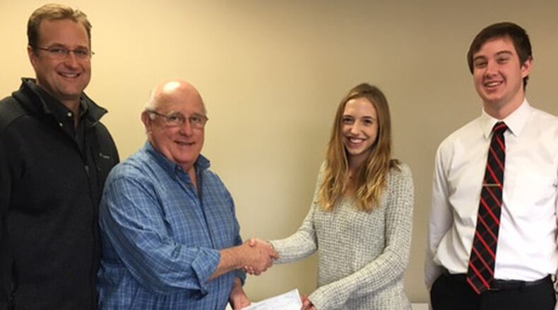 Greene Giving board members Jamie Hensley (left) and Jerry Pfiefer present a donation to Beavercreek High School cross country members Jordan Grant (senior class president) and Noah Buell (vice president). CONTRIBUTED PHOTO