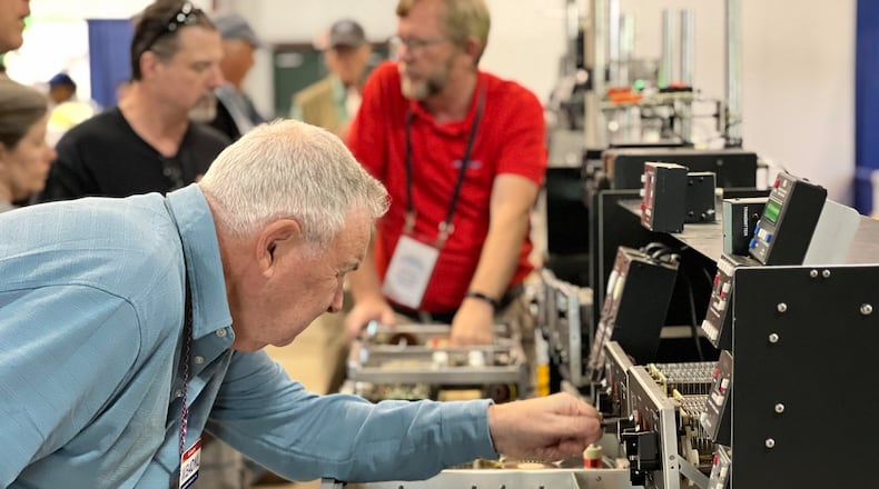 A visitor to the 2023 Dayton Hamvention, held at the Greene County Fairgrounds & Expo Center, tinkers with a display. This annual event attracts amateur radio enthusiasts from around the world. AIMEE HANCOCK/STAFF