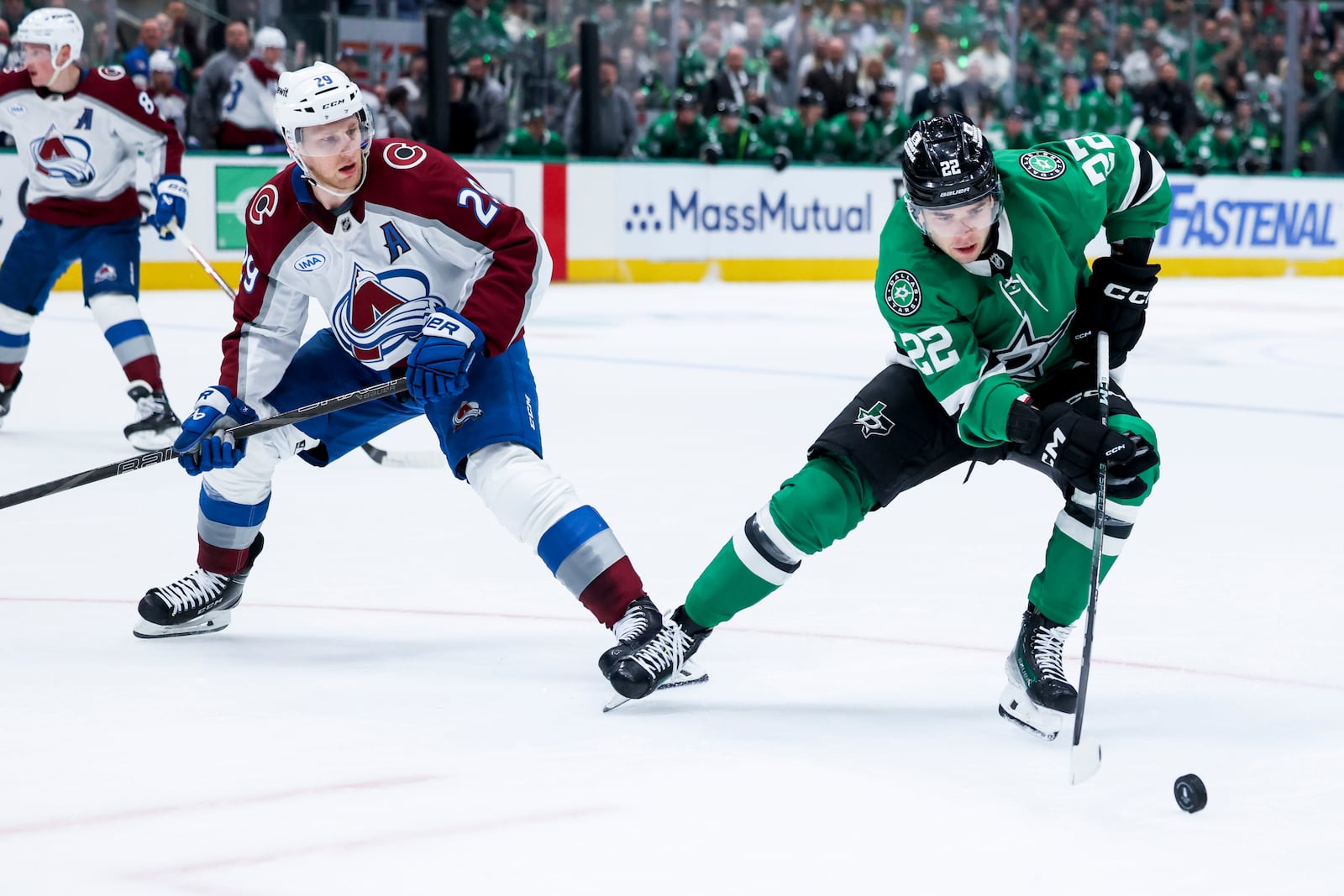 Dallas Stars center Mavrik Bourque (22) controls the puck as Colorado Avalanche center Nathan MacKinnon (29) looks on during a first-round NHL hockey playoff game in Dallas, Saturday, April 19, 2025. (AP Photo/Gareth Patterson)