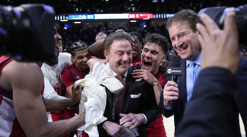 St. John's head coach Rick Pitino, center, is congratulated by his team after earning his 900th career coaching win against Xavier, Saturday, Jan. 24, 2026, in Cincinnati. (AP Photo/Kareem Elgazzar)