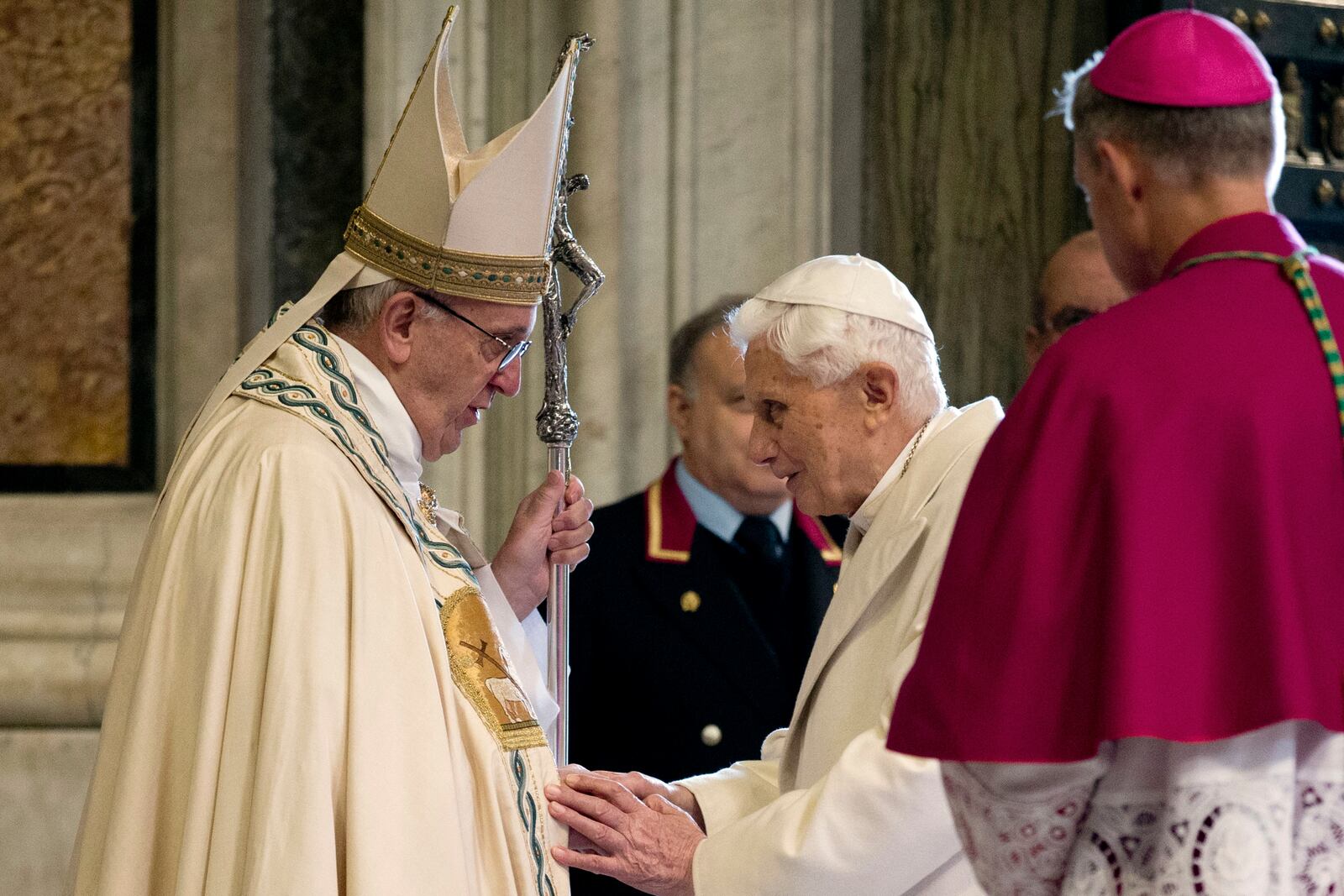 FILE - Pope Francis, left, stands in front of Emeritus Pope Benedict XVI entering St. Peter's Basilica accompanied by Monsignor Georg Gaenswein, right with back to camera, at the Vatican, Tuesday, Dec. 8, 2015. (AP Photo/Andrew Medichini, file)