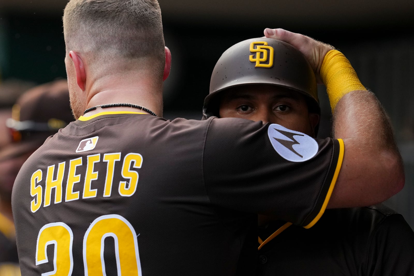 San Diego Padres' Luis Arraez, right, is embraced by Gavin Sheets (30) after hitting a solo home run during the fifth inning of a baseball game against the Cincinnati Reds, Saturday, June 28, 2025, in Cincinnati. (AP Photo/Jeff Dean)
