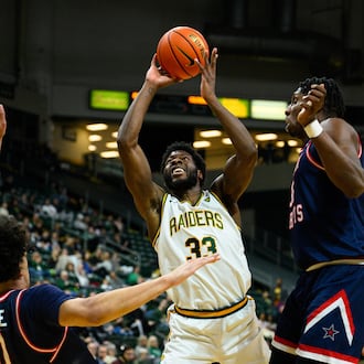 Wright State University's Michael Imariagbe shoots the ball between two Robert Morris University defenders during their game against Robert Morris University on Sunday, Feb. 22, 2026 at the Nutter Center. The Colonials won 81-68. JEREMY MILLER / CONTRIBUTED PHOTO