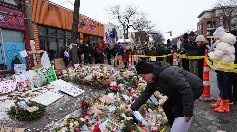 People visit a makeshift memorial for 37-year-old Alex Pretti, who was fatally shot by a U.S. Border Patrol officer over the weekend, Monday, Jan. 26, 2026, in Minneapolis. (AP Photo/Adam Gray)