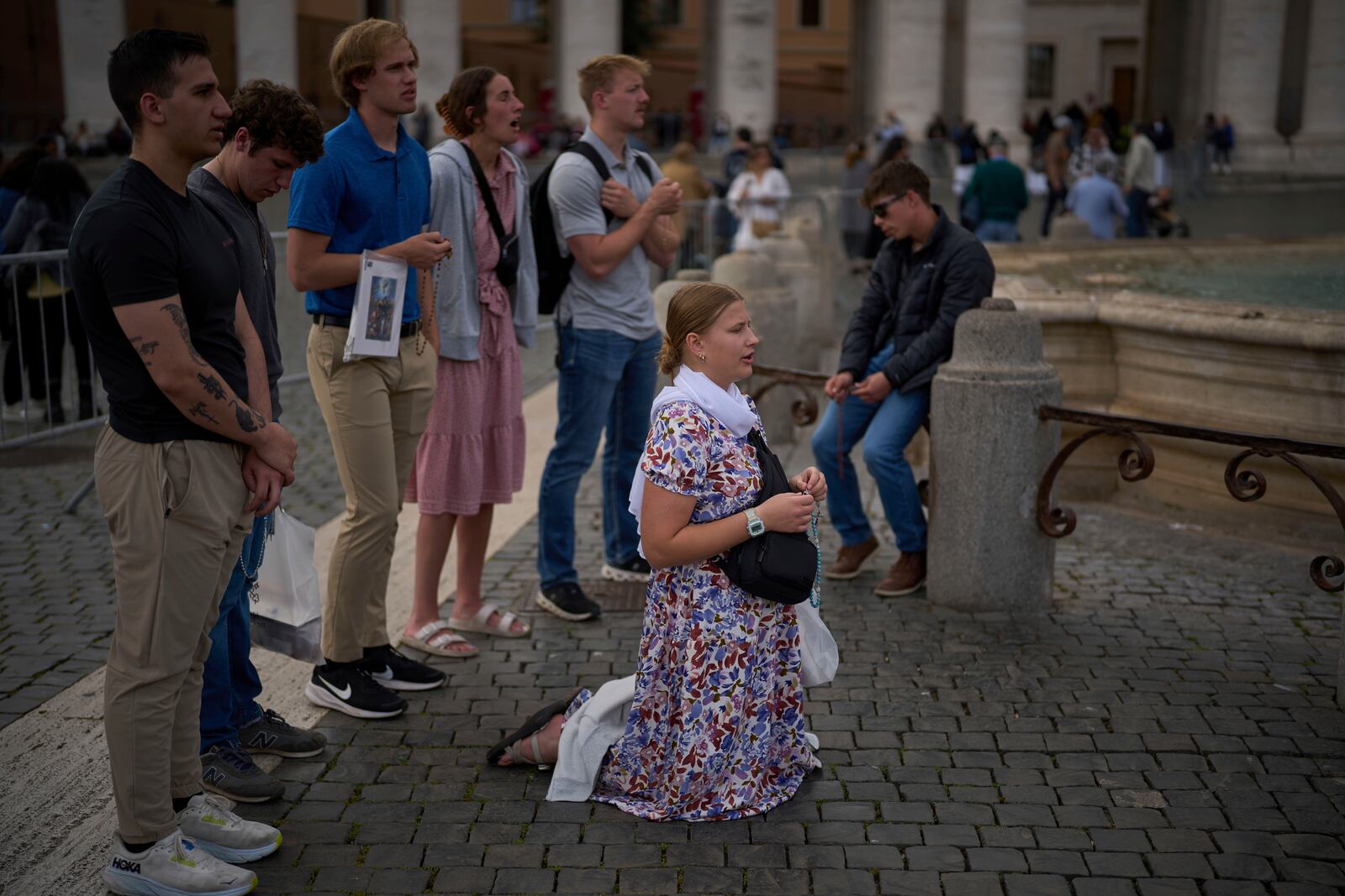 Worshippers from the United States pray outside St. Peter's Basilica where Pope Francis lying in state, at the Vatican, Friday, April 25, 2025. (AP Photo/Emilio Morenatti)