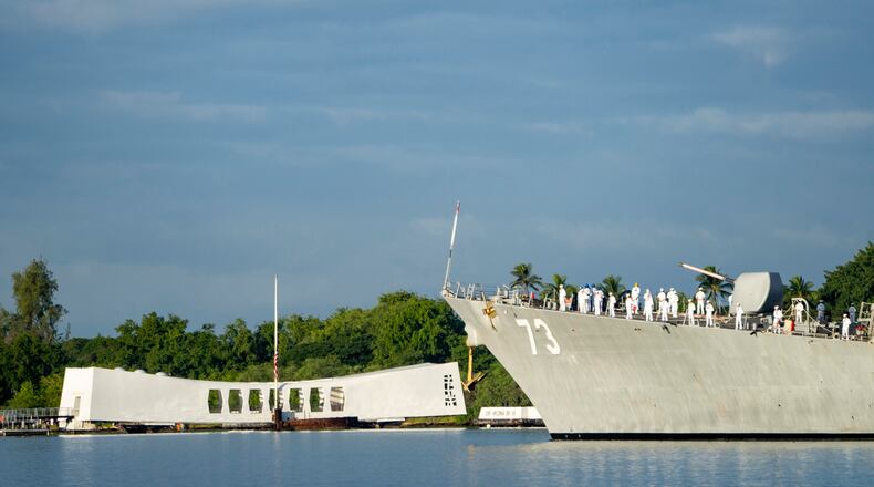Sailors aboard the the USS Decatur render honors while passing the USS Arizona Memorial and the sunken battleship the USS Arizona during the 82nd Pearl Harbor Remembrance Day ceremony on Thursday, Dec. 7, 2023, at Pearl Harbor in Honolulu, Hawaii. (AP Photo/Mengshin Lin)