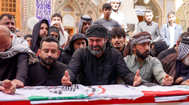Relatives pray near the coffin of an Iranian-backed Popular Mobilization Forces fighter killed in recent airstrikes on Qaim, Tuesday, March 17, 2026. in Najaf, Iraq. (AP Photo/Anmar Khalil)