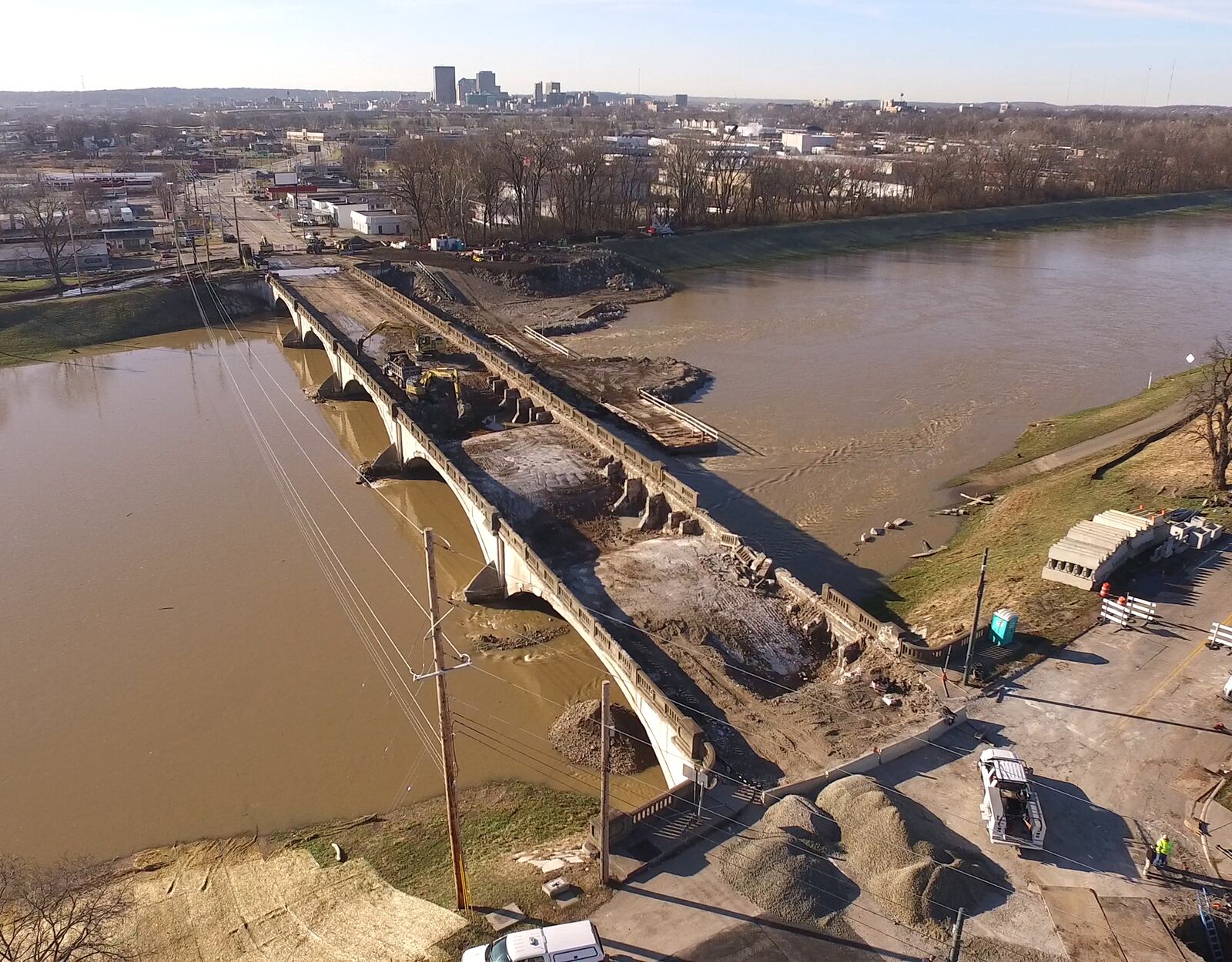 Contractors have started the demolition process for the old Keowee Street Bridge over the Great Miami River.  Decking has bee removed about halfway across the span.  Dirt and foundry slag that filled the concrete based bridge is being removed before the concrete structure is demolished. The bridge replacement will take about two years according to Montgomery County Engineer Paul Gruner.   TY GREENLEES / STAFF