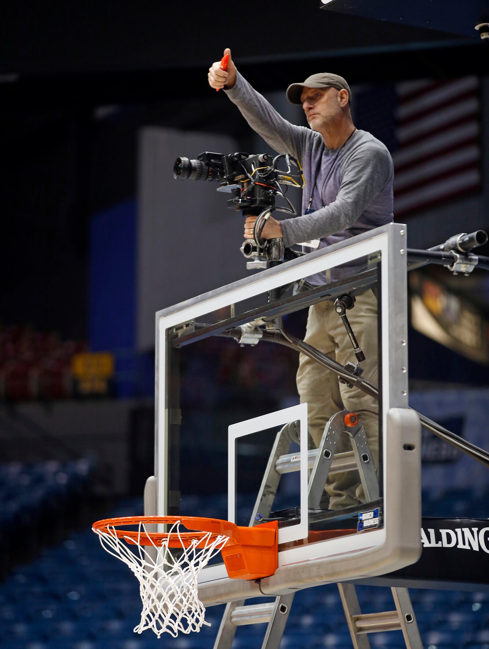 Rick Beattie checks his remotely mounted video camera before the practices started for the NCAA Tournament First Four at UD Arena on Monday night.  TY GREENLEES / STAFF