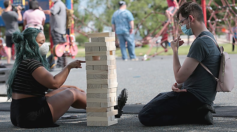 Courtney Burrs and Johnathan Anderson, both from Dayton, play Jenga during the "protestival" at McIntosh Park in Dayton Saturday, June 13, 2020. E.L. Hubbard for the Dayton Daily News