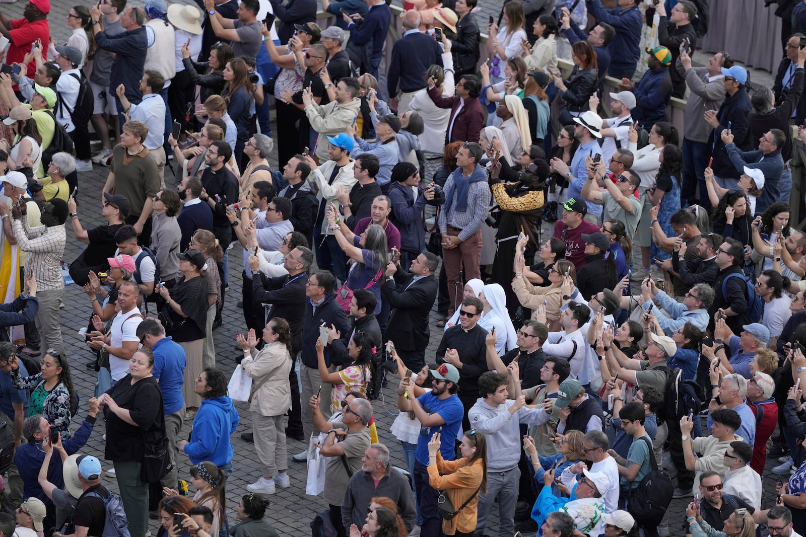 People watch as the black smoke billows from the chimney of the Sistine Chapel where 133 cardinals are gathering on the second day of the conclave to elect a successor to late Pope Francis, at the Vatican, Thursday, May 8, 2025(AP Photo/Markus Schreiber)