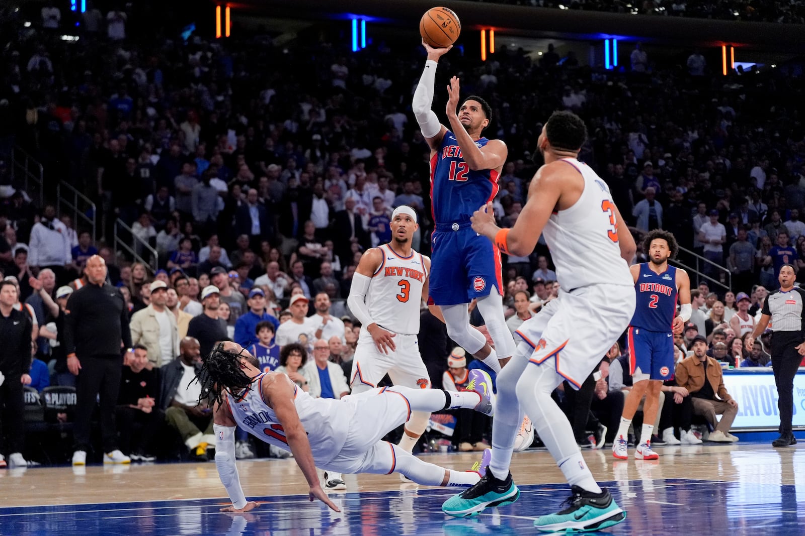 New York Knicks guard Jalen Brunson (11) falls as Detroit Pistons forward Tobias Harris (12) shoots during the second half of Game 1 in an NBA basketball first-round playoff series, Saturday, April 19, 2025, in New York. (AP Photo/Julia Demaree Nikhinson)