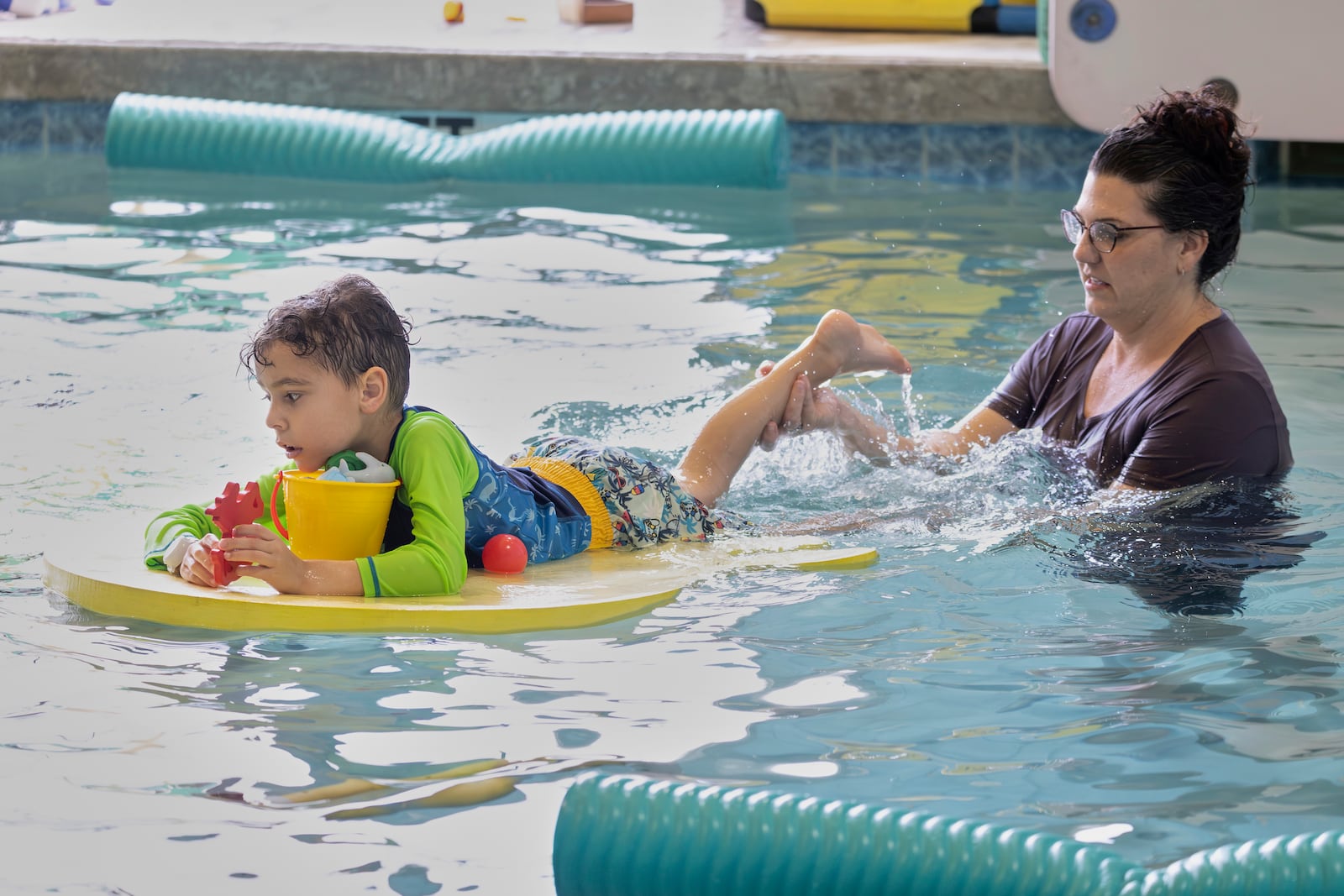 In this handout photo provided by Children's Services Council of Palm Beach County, occupational therapist Angelina Price, from The Learning Center, guides a student in the water during an autism-specific swim class at Small Fish Big Fish, Tuesday, April 1, 2025 in West Palm Beach, Fla. (Ben Rusnak /Children's Services Council of Palm Beach County via AP)